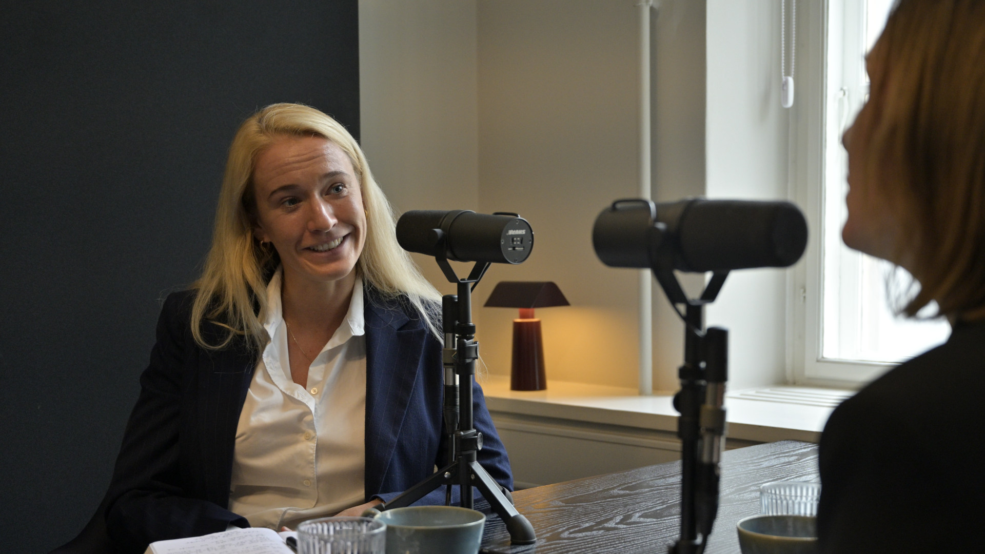 Maria Anker sidder i podcaststudiet og taler i mikrofon under optagelsen af Det, du leder efter