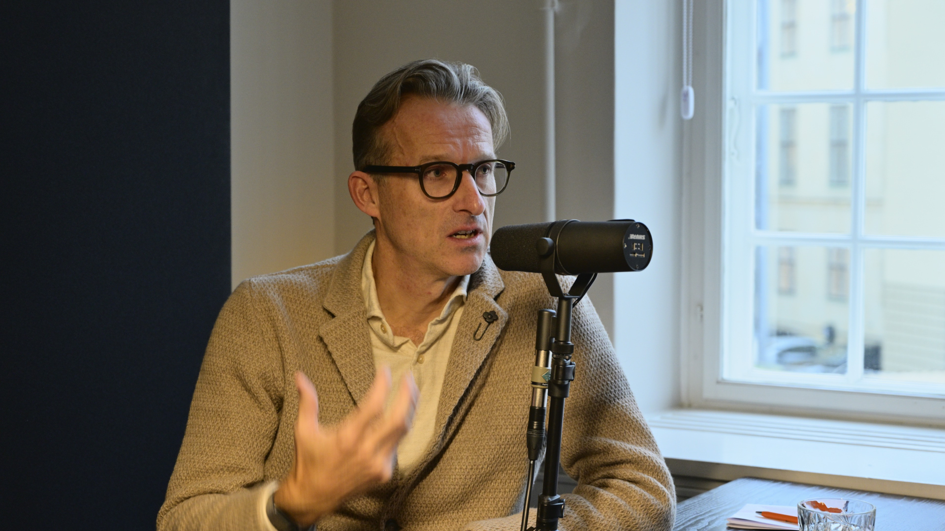 Gorm Rasmussen taler i mikrofon i bro fm-studiet under interview om ledelse af en familieejet virksomhed.