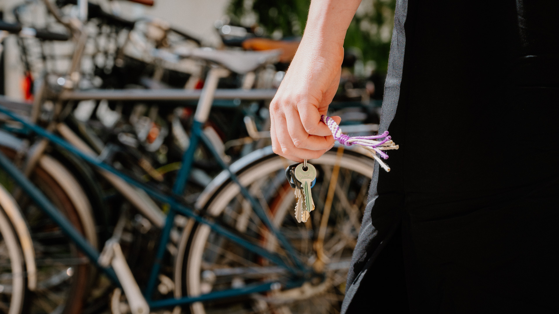 Kvinde står med nøgler i hånden. Skal beslutte om hun tager cyklen.