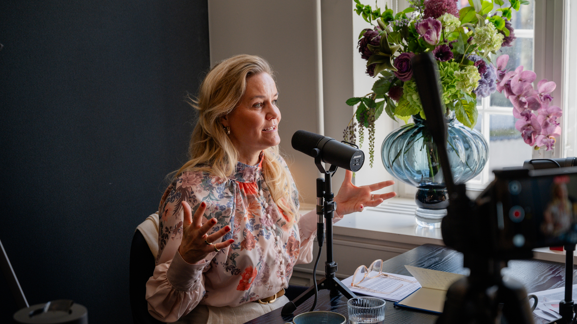 Susanne Dahl taler i mikrofon under optagelsen af bro fm podcast om ledelse i kriser, håb og ansvar